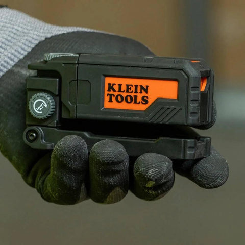 Hand holding Magnetic Pocket Laser Level with 360 Degree Wall Attachment, compact size, labeled Klein Tools