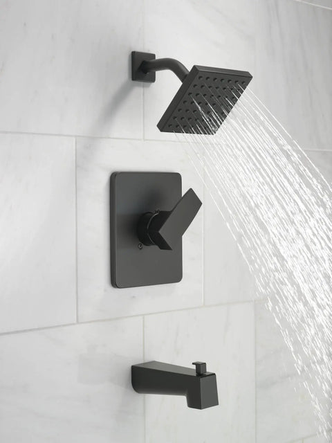 Dope Modern 14 Series Square Bathtub And Shower Faucet Set In Matte Black installed on white tile, water flowing from shower head.
