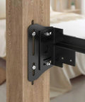 Rugged Bed Frame Connector Plates 2 Pack Universal Headboard Adapter Bracket Offset Mounting Hardware For Queen King Twin Size Adjustments and Dead Simple Swaps close-up of black steel bracket mounted on wood bed post.