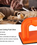 Safety Orange Oblique Push Block For Table Saws And Router Tables Featuring Steady Grip and Non Slip Base on workbench with wood.
