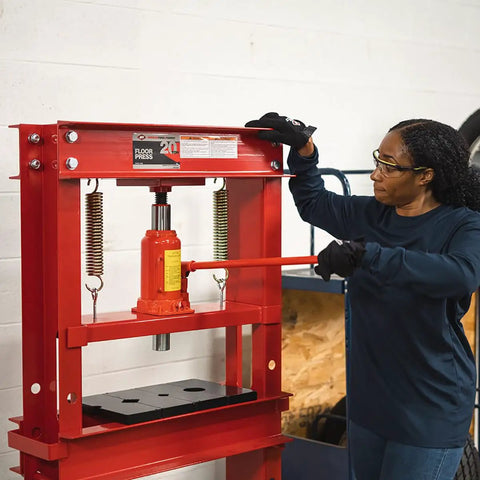 Woman operating a 20 Ton Hydraulic Shop Press for Gear Bearing and Bushing Removal Straightening and Bending Heavy Duty Industrial Grade Beast.