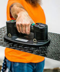 Portable Electric Vacuum Suction Cup Lifter For Wood Tile Marble Drywall Heavy Duty Hand Tool With Two Batteries Moves Three Seventy Five Pounds No Sweat Construction Hauling lifting a textured metal panel.