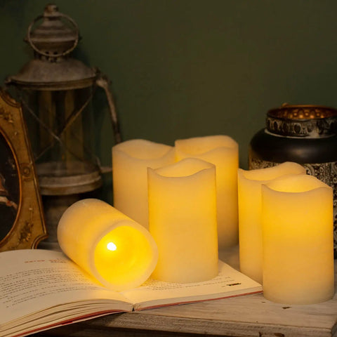 Flickering Flameless LED Candles Real Wax Pillar Set Of 6 with warm glow, 5 inches tall by 3 inches wide, displayed on a table.