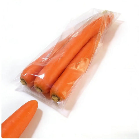 Compact Horizontal Flow Wrapper Shrink Wrap Machine 50 To 80 Pieces Per Minute wrapping fresh carrots in clear plastic packaging.