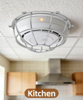 Heavy Duty Metal Detector Guard Cover And Fire Alarm Protector With Tool Less Quick Mount For Sprinkler Heads And Smoke Sensors In Homes Offices Hotels Garages And Commercial Buildings Built Tough To Keep Things Secure mounted in a kitchen ceiling.