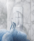 Upgraded Heavy Duty Nano Acrylic Gel Small Clear Adhesive Hooks 36 Pack Damage Free Mini Wall Hangers holding a blue loofah on tiled wall.