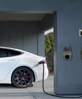 Slick Wall Mount Charging Cable Organizer For Tesla With Beefy Chassis Bracket And Tight Grip Power Cord Holder For Model 3 Model Y Model S Model X Garage Setup Matte Black mounted on wall next to charging Tesla.