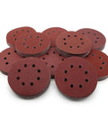 Premium 5 Inch Hook And Loop Sanding Discs With 8 Holes For Random Orbital Sanders stacked in a pile, featuring vibrant buffing wheels.