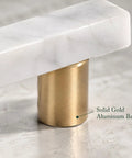 Close-up of Straight Up Premium White Marble Cabinet Pulls With Slick Gold Aluminum Drawer Handles, highlighting gold base.