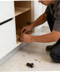 User installing 24 piece cabinet door repair pins kit with spring loaded hinge pins for plastic and metal cabinets in kitchen.