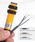 Person holding E3F DS30P1 Photoelectric Sensor with exposed wires, yellow M18 housing