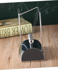 Z Shape Newtons Cradle Desk Toy For Home Office Decor with five silver balls and polished frame on a wooden desk
