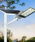 8000W LED Solar Street Light Dusk To Dawn Hella Bright Security Flood Lamp with solar panel and pole in garden setting