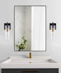 Wall-mounted Black Gold Wall Sconces Set Of Two With Clear Glass Shades Modern Metal Vanity Lights on each side of a mirror.