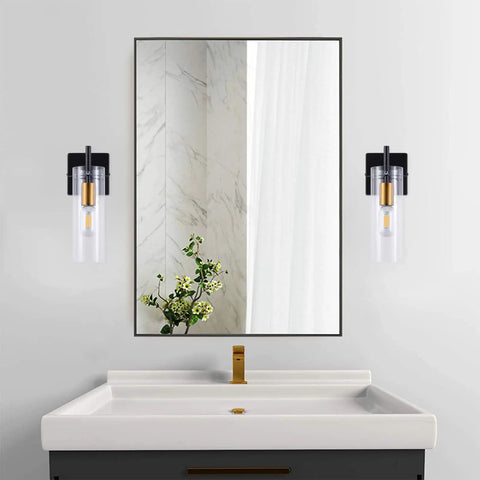 Wall-mounted Black Gold Wall Sconces Set Of Two With Clear Glass Shades Modern Metal Vanity Lights on each side of a mirror.