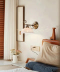 Ceramic Wall Sconce, 9 Inch Brass Vintage Light on a bedroom wall with delicate floral shade and antique brass finish.