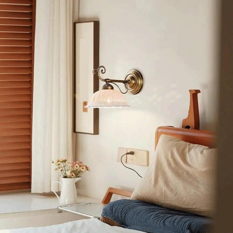 Ceramic Wall Sconce, 9 Inch Brass Vintage Light on a bedroom wall with delicate floral shade and antique brass finish.