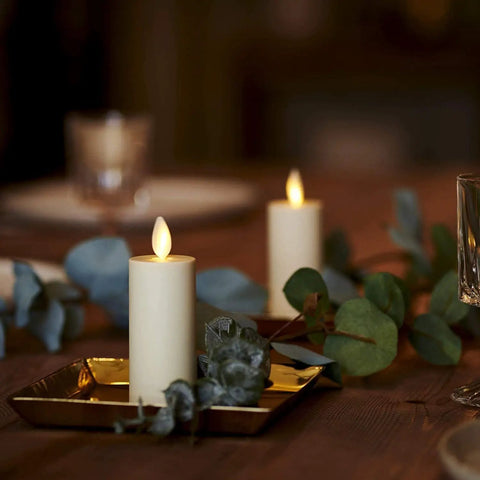 Outdoor Flameless LED Votive Candle Set of 2, Ivory 1.5 x 4 Inches, Moving Flame, on a tabletop with greenery decoration