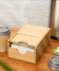 Spring Loaded Coffee Sleeve Dispenser For Homes And Restaurants Natural Bamboo Cup Sleeve Organizer Compact 9.5 Inch By 6 Inch By 3.75 Inch Holder With Wide Opening For Quick Grab Coffee Sleeves on a kitchen counter next to coffee cups