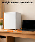 Compact 1.1 Cu Ft Upright Mini Freezer In Bright White For Dorms Small Apartments And Garages dimensions on desk beside laptop.