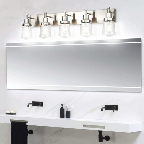 Five light brushed nickel vanity light fixture with clear glass shade over mirror for bathroom