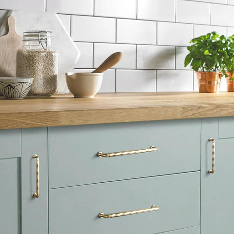 Champagne Bronze Cabinet Pulls 3 Inch Twisted Wave Design Set on modern kitchen drawers, showcasing zinc alloy construction.