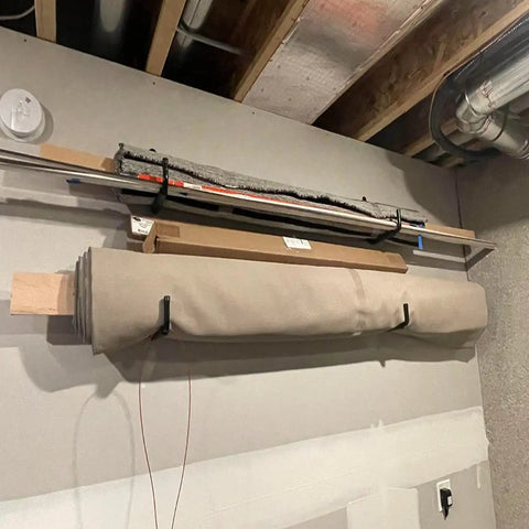 Heavy Duty Garage Storage Ladders Hooks Set 6 Pack Wall Mount Hangers holding rolled carpet and poles in a garage