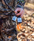 Hunter holding Double Scent Drag Deer Urine Kit For Scrapes And Ambush Hunts Buck And Doe Lure in amber glass bottles