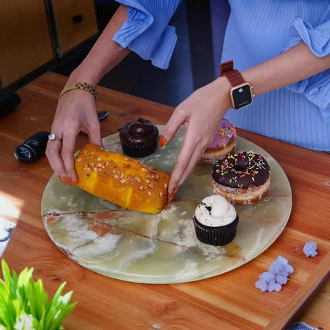 Person placing pastries on Large 16 Inch Marble Lazy Susan Round Rotating Serving Tray For Dining Table Kitchen Pantry And Home Decor Durable Marble Turntable For Condiments Appetizers And Everyday Organization On Countertops And Cabinets