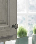 Oil Rubbed Bronze Edona One And A Quarter Inch Cabinet Knob Set on wooden cabinet, elegant traditional look, copper highlights.