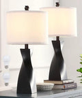 Two Pack Black Table Lamps With White Linen Shades For Bedroom And Living Room End Tables Set Of 2, Easy Three Minute Assembly, 9.5W LED Bulbs Included, Warm Cozy Nightstand Lighting on a table with books.