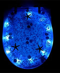 Top Shelf Soft Close Resin Toilet Seat With Built In Led Glow And Heavy Duty Stainless Steel Hinges Quick Release Mounting Kit, illuminated blue design.
