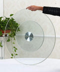 Person holding Tempered Glass Lazy Susan Turntable Rotating Tray for Dining Tables, showing size and 360° spin capability.