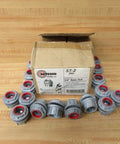 Tough As Nails 3/4 Inch Zinc Conduit Hub in a pack of sixteen around an open box on a wooden surface.