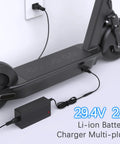 Universal 29.4V 2A Charger for 7S LiIon Batteries charging an e-scooter via a wall socket with interchangeable plugs.