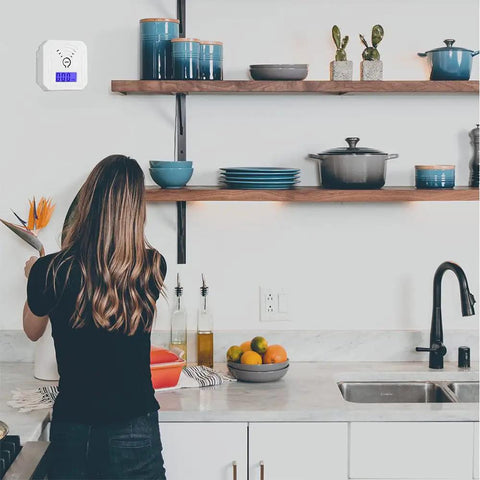 Woman arranging flowers in kitchen with Two Pack Carbon Monoxide Detector Alarm Battery Operated With Digital LCD Display on wall