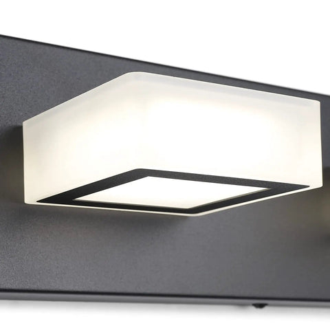 Close-up of Three Light Black Vanity Lighting Fixture With Acrylic Shades, modern design showing sleek black metal frame and natural white light