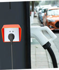 Badass Heavy Duty Ev Charger Cover And Weatherproof Outlet Protector For 86 Type Electrical Jack Plates with orange shell mounted over an outlet.