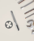 Rock Solid Precision Thread Tap And Die Set With Straight Flute Design For Handheld Convenience And Metal Construction, Perfect For Rapid Thread Repair And DIY Maintenance Tasks That You Can Actually Feel In Your Hands. steel tap, die, and drill bits on white background
