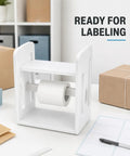 Premium Solid Wood Label Holder In Clean White, No Sweat Setup Printer Stand And Sticker Dispenser For Thermal Rolls And 4X6 Shipping Labels, displaying a roll on a desk.