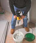 Person using Badass Torque One Half Inch Spade Handle Corded Drill With Nine Point Zero Amp Motor and Reversing Switch for mixing.