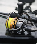 Real Smooth Spinning Fishing Reel Size 200 on a wet boat surface, showcasing aluminum spool and fishing line.