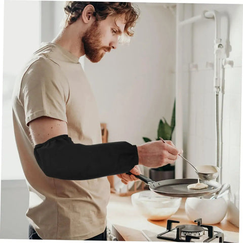 Six Pairs Oil Resistant Arm Sleeves Long Kitchen Cooking Oversleeves With Grippy Elastic Bands Keeping Your Clothes Clean During The Daily Hustle worn by a man cooking pancakes in a kitchen.