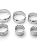 Set of seven round metal cookie cutters in varying sizes with plain and crinkled edges