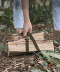 Person using Four Pack Of Heavy Duty Polyester Ratchet Luggage Straps For Rock Solid Gear Wrangling And Hassle Free Campsite Setup to carry firewood.