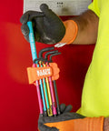 Technician holding color coded hex key wrench set with long arm L style and ball end SAE and metric 18 piece kit