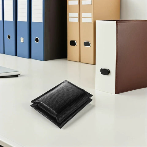 Black Bubble Mailers 13x18 Plus 4 Padded Envelopes With Self Seal Adhesive on office desk next to binders.