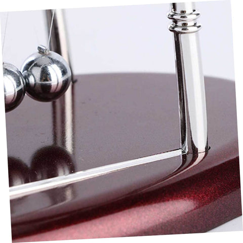Close-up of Large Newton Cradle Pendulum Desktop Physics Toy For Home Office Use Five Ball Demonstration, polished wood base