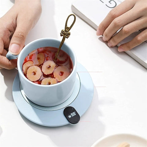 Compact Desk Coffee Warmer With Auto Shut Off And Waterproof Aluminum Base Keeps Your Morning Brew Steaming All Day with a blue cup and spoon.