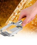 Hand using Stainless Steel Beehive Knife Scraper and Honey Uncapping Fork for Beekeeping Equipment with honeycomb background.